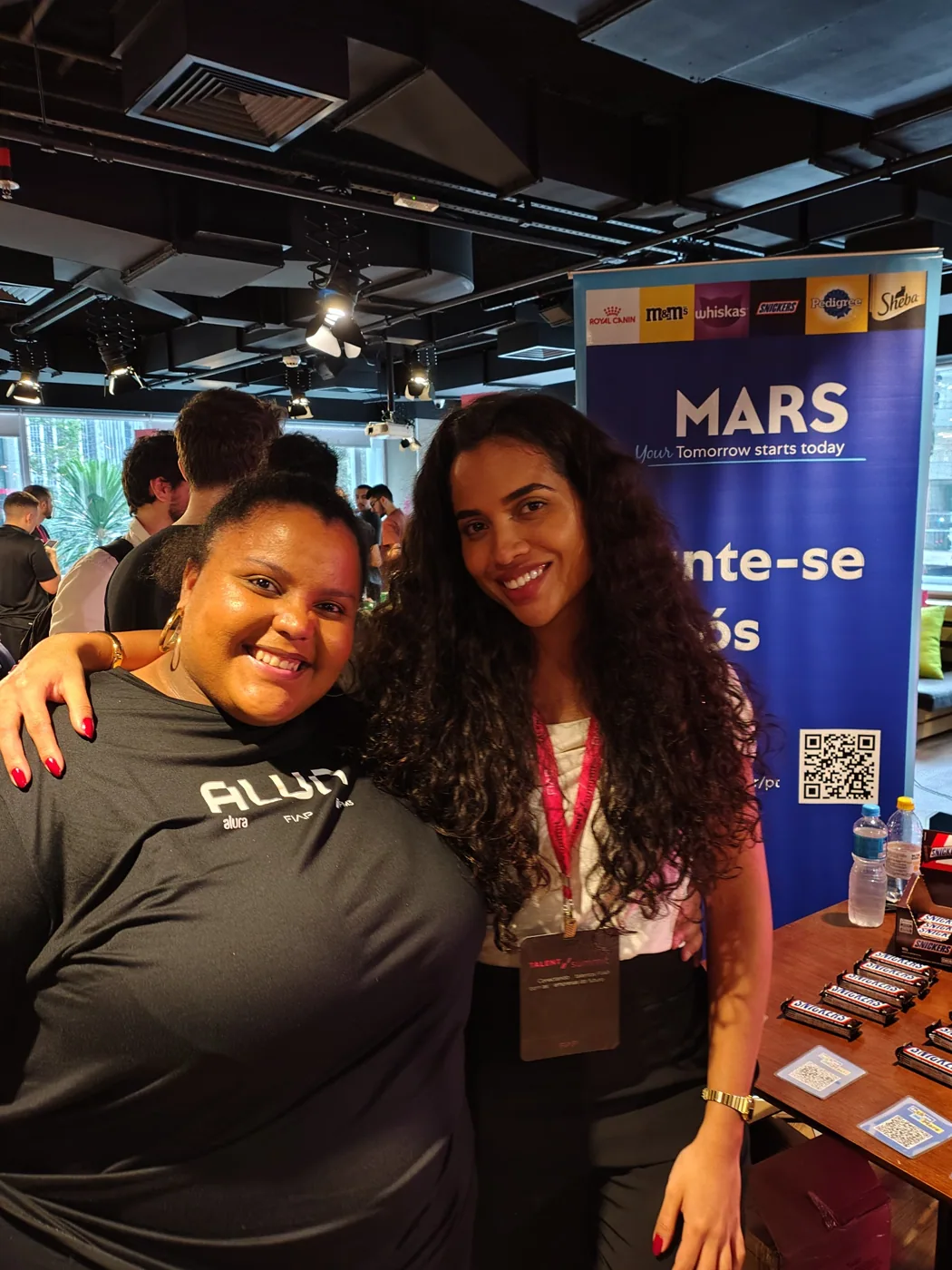 Registro junto ao estande da Mars no Talent Summit 2025; imagem reutilizada na seção 2026